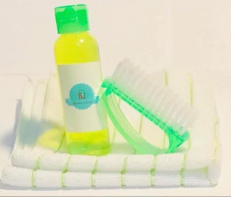 The first RJ Sneaker Cleaner bottle, brush and white towel on a white background