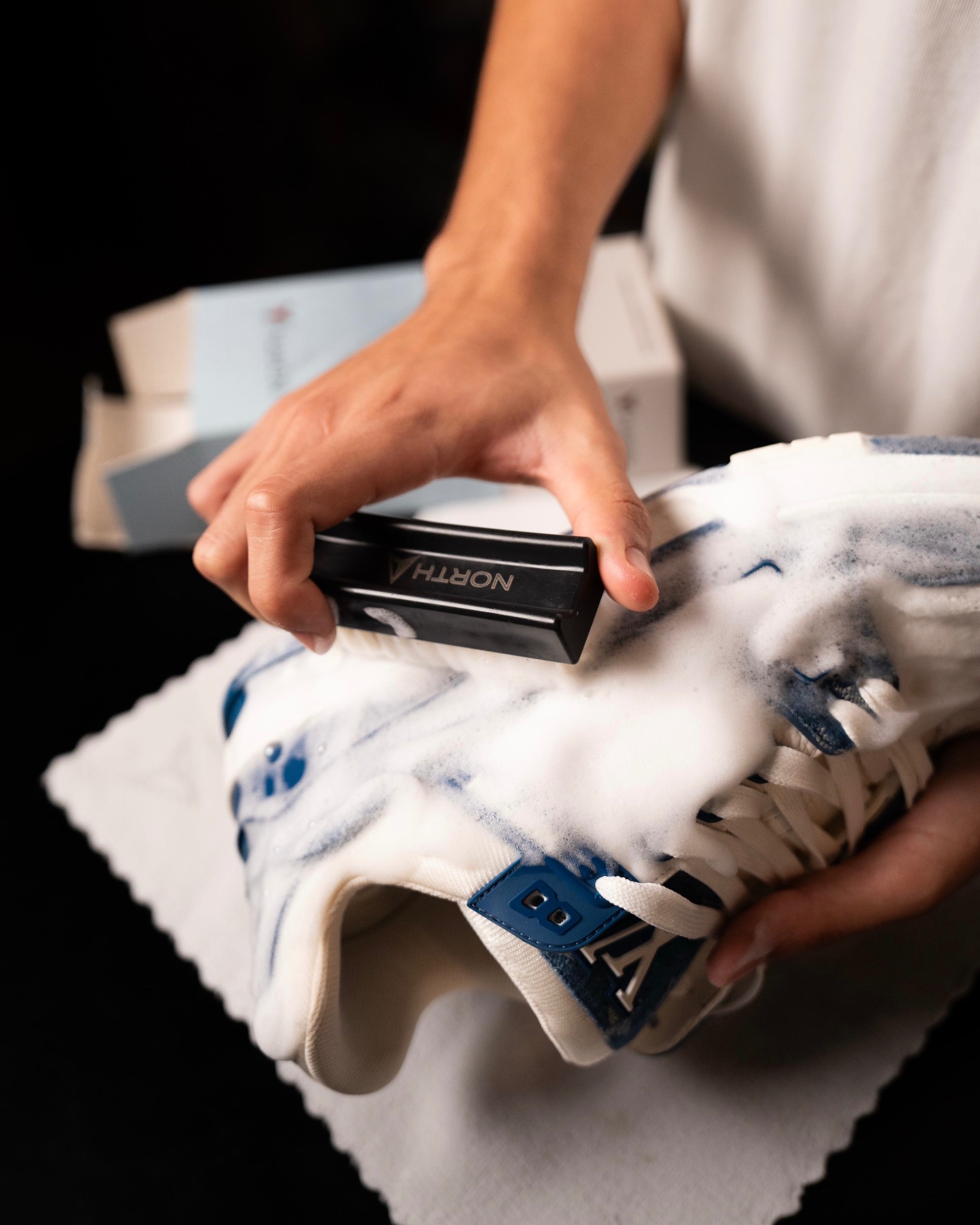 Hand scrubbing a foamed sneaker with the North brush