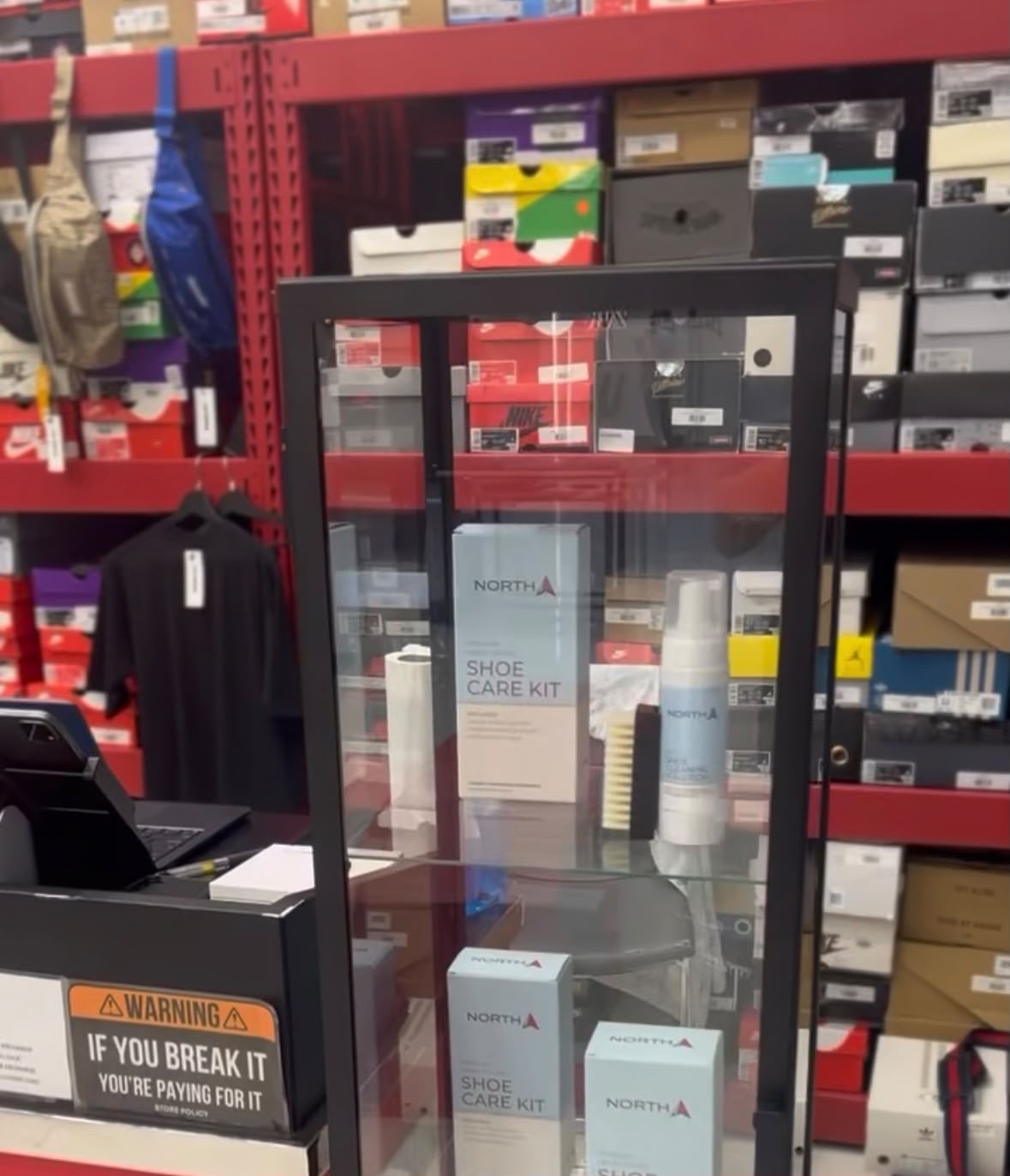 The NORTH Shoe Care Kit displayed in a glass case at a retail store counter